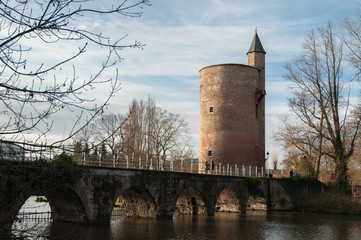 Tower over river bridge during sunset