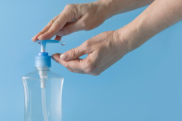 Woman washing hands with hand sanitizer to protect against Coronavirus infection. COVID-19.