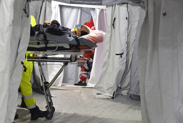 Patient with Corona Virus waits to be cured on the stretcher inside a hospital field tent for the...