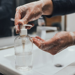 Fototapeta premium Washing hands with antibacterial soap at home bathroom for coronavirus prevention. Coronavirus pandemic protection by washing hands frequently. Hygiene to stop spreading coronavirus.