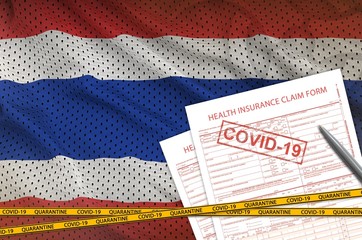 Thailand flag and Health insurance claim form with covid-19 stamp. Coronavirus or 2019-nCov virus...