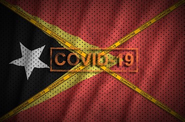 Timor Leste flag and Covid-19 stamp with orange quarantine border tape cross. Coronavirus or...
