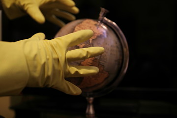 globe in hands wearing protective gloves