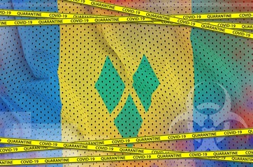Saint Vincent and the Grenadines flag and Covid-19 quarantine yellow tape. Coronavirus or 2019-nCov...