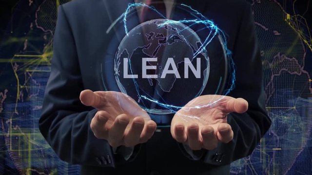 Male hands activate a conceptual holographic text Lean. Businessman in a suit with a hologram of planet Earth on a background of a futuristic wireframe city