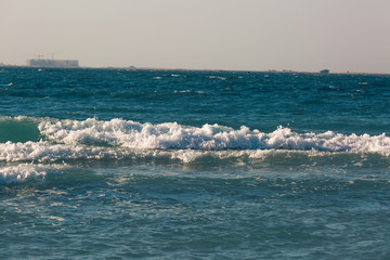 Tropical beach white sand, blue clear ocean water. sea foam on the beach on a sunny day. sea waves...
