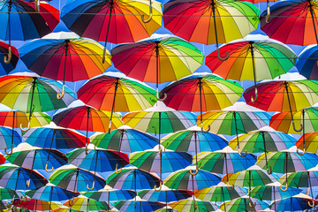 Fototapeta na wymiar Colorful umbrellas Blue, green, red, rainbow umbrellas background Street with umbrellasin the sky Street decoration.