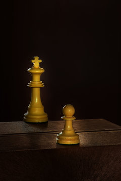 King and chess pawn in the darkness
