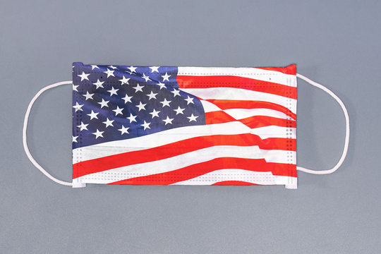 Isolated medical mask with flag of USA on gray background. Closeup protective masks textile filter. Health care and medical concept. Coronavirus, virus in US.