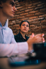Happy millennial couple listens carefully to their financial consultant over a coffee meeting
