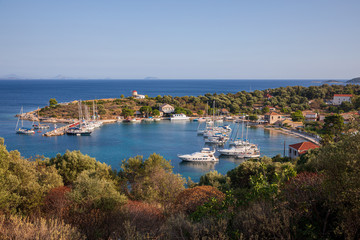 Fototapeta na wymiar Port of Kastos island with moored yachts, sailboats, boats - Ionian sea, Greece in summer.