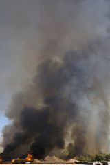 Fototapeta na wymiar Brush fire in desert emitting large black plumes of smoke, east of Needles in Arizona