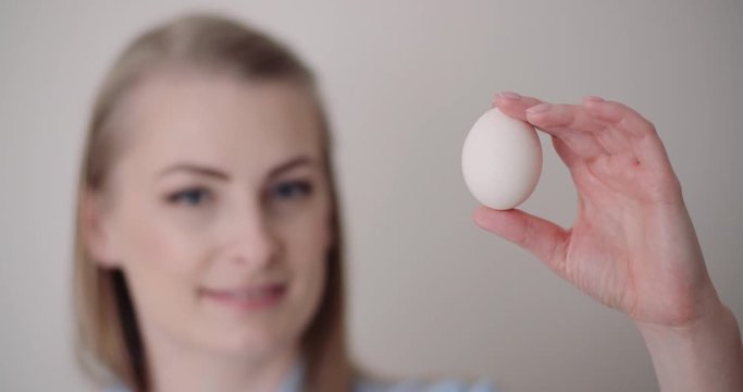Happy Easter - smiling woman holding egg in hand