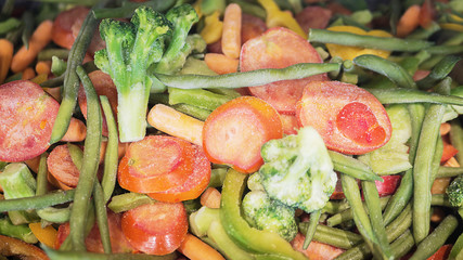 Frozen vegetable mix tomato, broccoli, pepper, bean, carrot, asparagus. Cut freeze vegetables. Vegan and vegetarian food. Healthy dinner idea. Pieces and cubes of veggies, diced. Selected soft focus