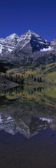 Panoramic view of autumn colors of Aspens reflecting in lake under Maroon Bells, Colorado, near Aspen