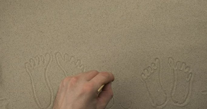 Drawing in the sand in real time. Beach drawing for leisure and travel advertising.