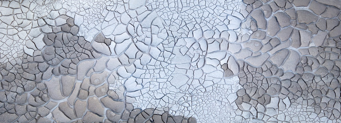 Abstrakte Struktur von getrocknetem rissigen Schlamm in verschiedenen Grautönen - Panorama Detail