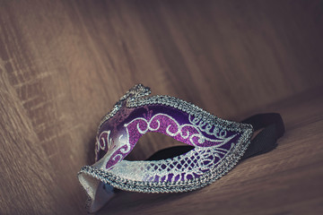 Fototapeta premium purple, magenta and silver venetian carnival mask isolated in wood background