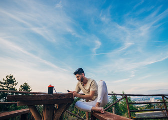 Man enjoying nice day and playing online games with a smart phone outdoor