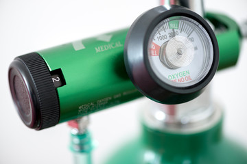 Detail of an oxygen pressure gauge and cylinder with white background