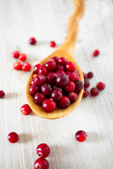 fresh cranberries on white wooden surface