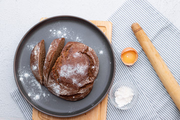 black bread. Homemade cake. Black bread is sprinkled with flour. Freshly baked homemade artisan rye and white flour bread. The view from the top.