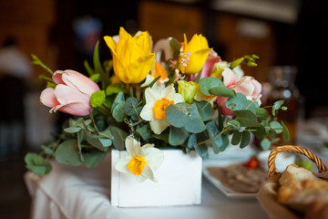 Rustic wedding bouquet with roses and eucalyptus, lilac on green grass and wooden texture.