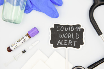 Text phrase: COVID 19, WORLD ALERT, with medical equipment on white background.