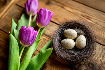 Purple tulips and easter eggs on wooden table. Holiday concept