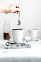 Woman pouring hot chocolate into a cup dropping from a spoon