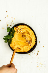 Homemade hummus with sticks to eat decorated with coriander chopped nuts