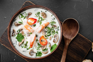 Chinese dishes in a clay plate on a black concrete background with ingredients for delivery