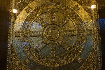 The gold plated Buddhist swastika decoration near the Buddha relics in the Botahtaung Pagoda, Yangon, Myanmar
