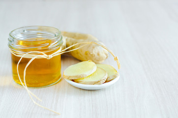 honey and ginger root on light wooden background with copy space. prevention and treatment of colds