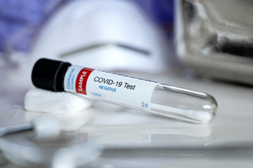 Negative results testing for presence of coronavirus. Tube containing a swab sample for COVID-19...