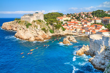 Fototapeta na wymiar Summer mediterranean cityscape - view of the the Fort Lovrijenac and harbor with a group of kayaks, the Old Town of Dubrovnik, on the Adriatic coast of Croatia
