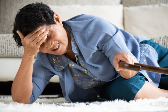 Sick Asian Old Woman With Headache Lying On The Floor After Falling Down At Home. Senior Healthcare Concept.