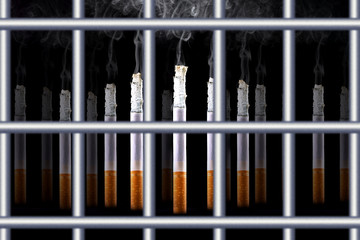 Smoking cigarettes behind iron bars. Ban on smoking.