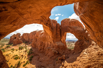 Stunning view of Double Arch in Arches National Park, Utah in the summertime with blue sky background. Travel, tourism, desert landscape area in popular road trip area.