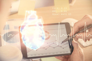 Double exposure of man's hands holding and using a phone and heart drawing. Medical education concept.