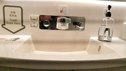 Bathroom sink in a commercial airplane with personal cleaning products