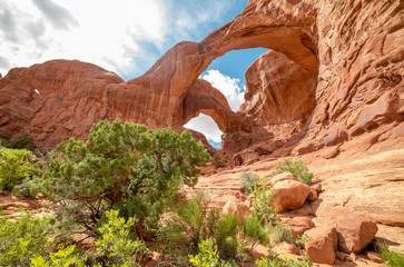 Stunning view of Double Arch in Arches National Park, Utah in the summertime with blue sky background. Travel, tourism, desert landscape area in popular road trip area.