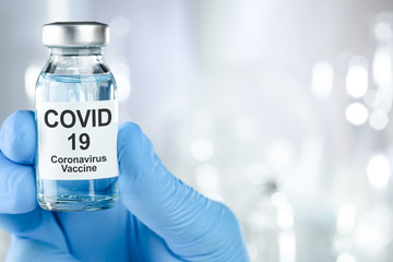 Healthcare cure concept with a hand in blue medical gloves holding Coronavirus, Covid 19 virus,...