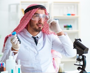 Naklejka premium Arab chemist working in the lab office