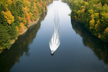 A boat navigates the Connecticut River through autumn color on the Mohawk Trail of western...