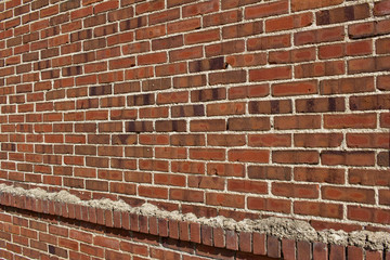 Shabby chic old brown and red brick wall texture with light colored mortar (angle view)