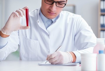 Young doctor in the lab with red tube