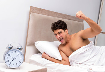 Young man having trouble waking up in the morning