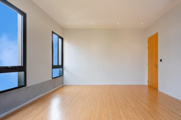 Fototapeta na wymiar Empty room interior with windows overlooking the blue sky, Beautiful wooden floor and white wall modern office building or home and living architecture