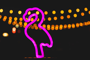 pink flamingo lamp at night with candles and bokeh background